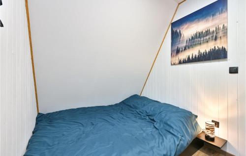 Un dormitorio con una cama azul con una foto en la pared en Awesome Home In Ivanec With Sauna, en Ivanec
