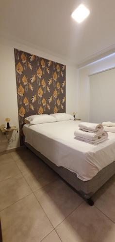 1 dormitorio con 1 cama blanca grande y cabecero en Alem 5 - Bon Repos en San Miguel de Tucumán