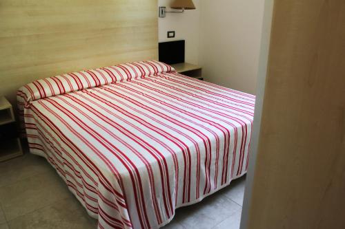 1 cama con manta a rayas en una habitación en Villaggio Baia Del Monaco en Manfredonia
