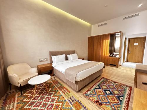 a bedroom with a bed and a chair and a rug at HOTEL MODERNO & Spa in Tashkent