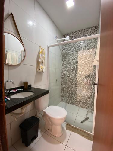 a bathroom with a shower and a toilet and a sink at Pousada Vila das Lagoas in Santo Amaro