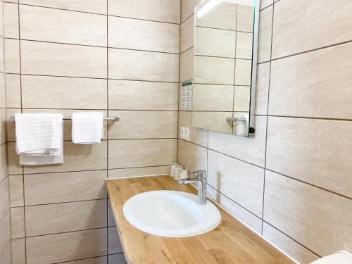 een badkamer met een wastafel en een spiegel bij Logis Grand Hotel Bain in Comps-sur-Artuby