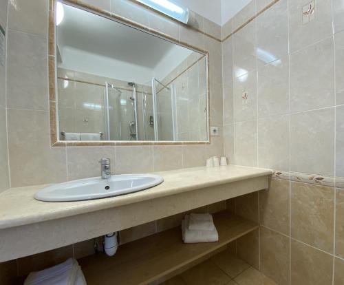 a bathroom with a sink and a mirror at Logis Grand Hotel Bain in Comps-sur-Artuby