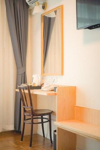 a room with a desk with a chair and a mirror at Ago Hotel Chinatown in Bangkok