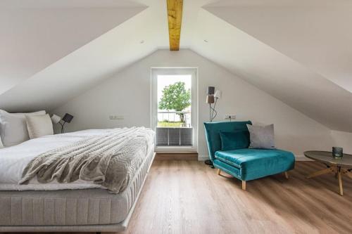 1 dormitorio con 1 cama y 1 silla azul en 5 Sterne-Ferienhaus Eisvogel am See mit Sauna und Kamin en Krakow am See