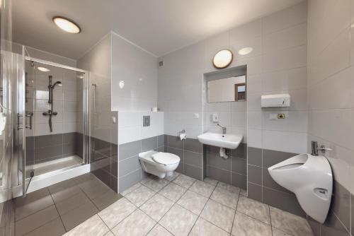 La salle de bains est pourvue de toilettes, d'un lavabo et d'une douche. dans l'établissement Hostel Białystok Centrum, à Białystok