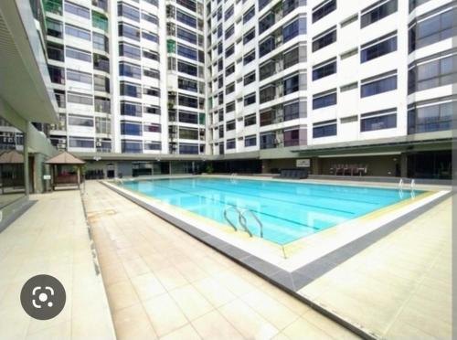 a large swimming pool in a building with tall buildings at Fahrenheit Condo Bukit Bintang KL in Kuala Lumpur