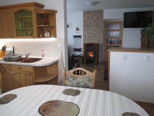 a kitchen with a table and a kitchen with a fireplace at Chalupa Maršovice in Nové Město na Moravě