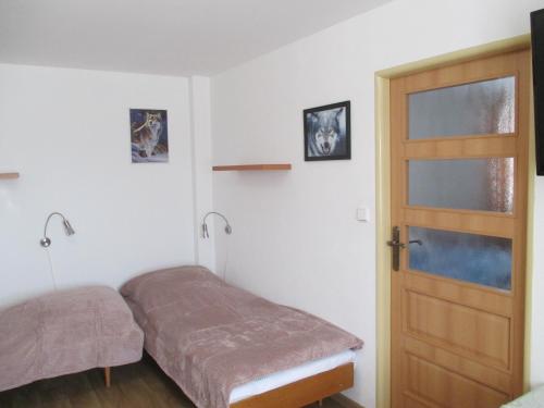een kleine slaapkamer met een bed en een deur bij Chalupa Maršovice in Nové Město na Moravě