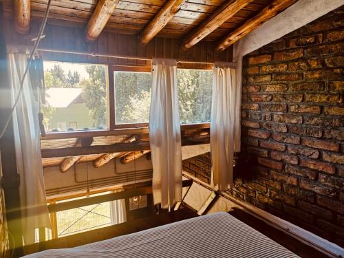 sypialnia z ceglaną ścianą i oknem w obiekcie Bungalows Luz del sur w mieście Bariloche