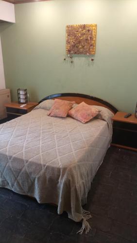 um quarto com uma cama com duas almofadas em CABAÑAS VILLA CLUB 3 cerca del aeropuerto el palomar em Hurlingham