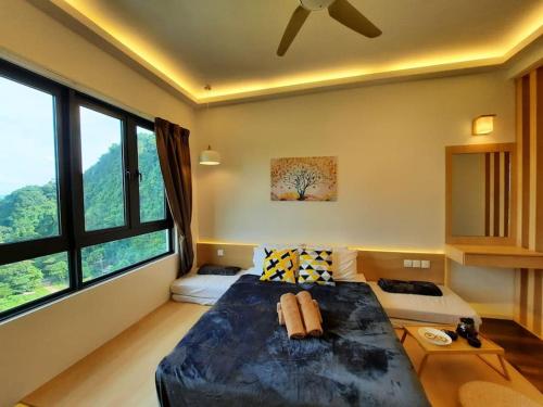 a bedroom with a large bed and large windows at Onsen Suite at Sunway Lost World Tambun in Ipoh