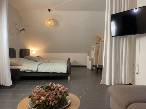 a living room with two beds and a table with flowers at Gemütliche Wohnung in Ahaus