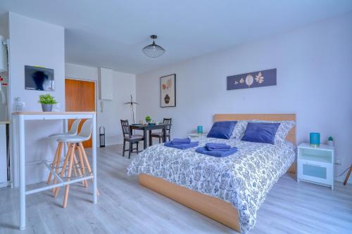 a bedroom with a bed and a kitchen and a table at Logement Elora in Evry-Courcouronnes