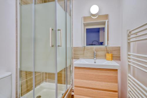 uma casa de banho com um chuveiro e um lavatório. em Logement Elora em Courcouronnes