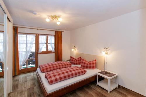 a bedroom with two beds with red pillows at Hotel Binderhäusl in Berchtesgaden