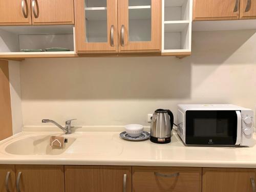 a kitchen counter with a microwave and a sink at Supalai Oriental Place in Bangkok