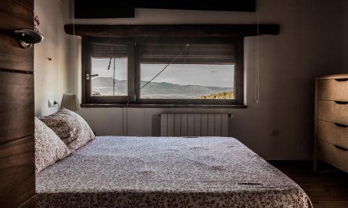 Schlafzimmer mit einem Bett vor einem Fenster in der Unterkunft Posada del Candil in Serón