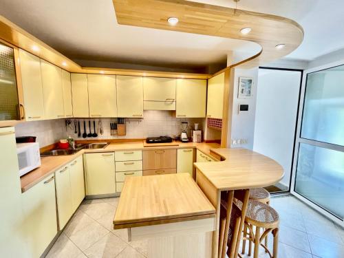 a kitchen with yellow cabinets and a wooden table at Eden sul Lago di Como in Nesso
