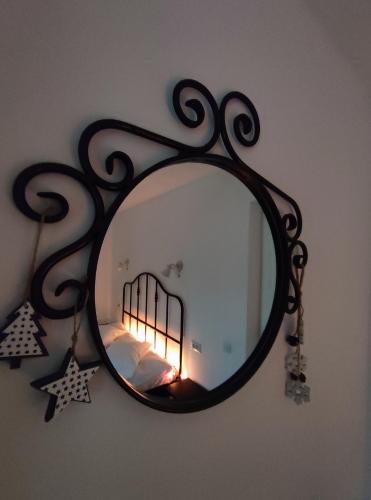 a mirror on a wall with a bed in a room at Cozy Attic Azuga in Azuga