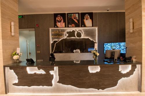 a lobby with a counter with a painting on the wall at Grand day in Al Hofuf