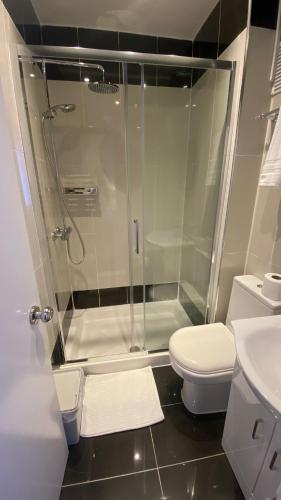 Un baño con ducha, inodoro y lavabo. en Prime Inn, en Londres