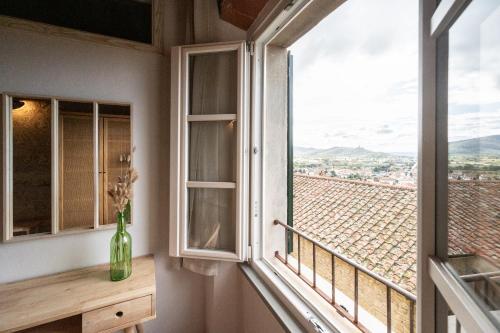 a room with a window with a vase on a table at Casa La Girandola in Castiglion Fiorentino