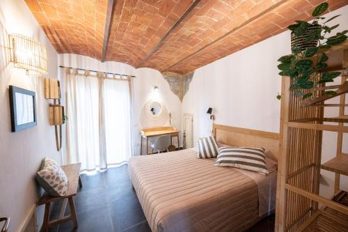 a bedroom with a bed and a wooden ceiling at Casa La Girandola in Castiglion Fiorentino