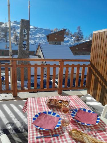 une table avec des plaques alimentaires sur un pont dans l'établissement Val d'Azur Plein sud Face aux Pistes, à Valberg