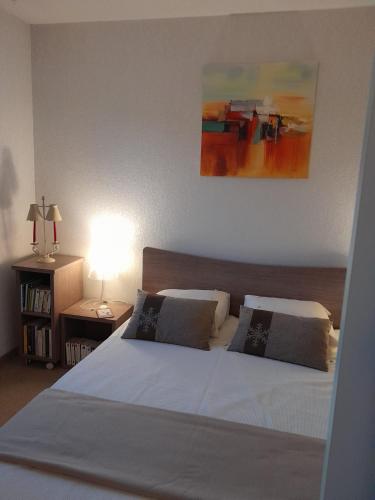 une chambre avec deux lits et un tableau au mur dans l'établissement Val d'Azur Plein sud Face aux Pistes, à Valberg