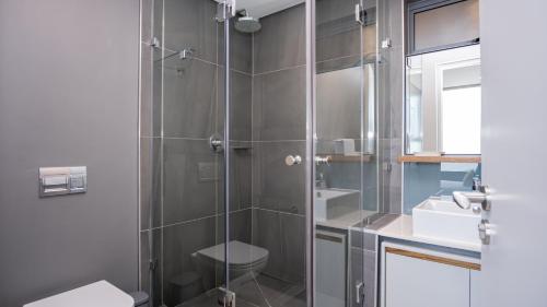 a bathroom with a shower with a toilet and a sink at Umhlanga Arch Luxury in Durban