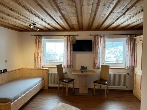 a bedroom with a bed and a table and chairs at Pöchtlhof in Leogang