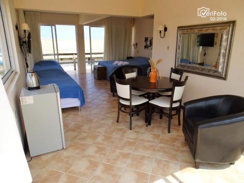 een woonkamer met een eettafel en een slaapkamer bij Hotel Aquarella in Punta Del Diablo