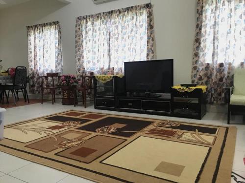a living room with a television and a rug at Homestay Din’s in Semporna