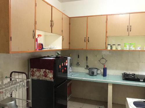 eine Küche mit einem schwarzen Kühlschrank und einer Theke in der Unterkunft Homestay Din’s in Semporna