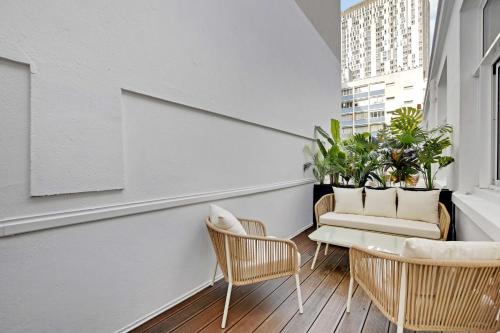 un balcon avec des chaises et une table sur un immeuble dans l'établissement Magnificent apartment - 2BR-6P - Eiffel Tower, à Paris