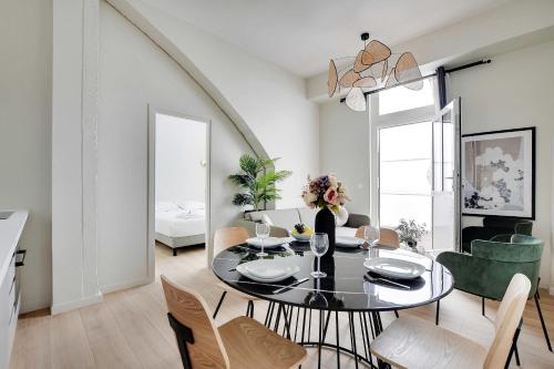 une salle à manger avec une table et des chaises noires dans l'établissement Magnificent apartment - 2BR-6P - Eiffel Tower, à Paris