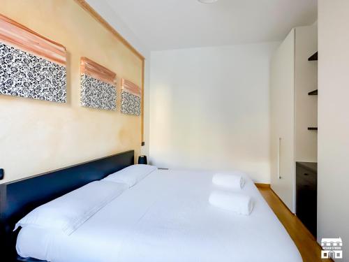 a bedroom with a large bed with white sheets at AL LAGO by Design Studio in Bellano