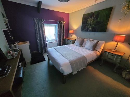 1 dormitorio con 1 cama, 2 lámparas y ventana en Hideaway Escapes, Farmhouse B&B & Holiday Home, Ideal family stay or Romantic break, Friendly animals on our smallholding in beautiful Pembrokeshire setting close to Narberth, en Narberth