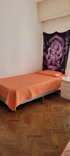 a bed in a room with a wooden floor at Habitaciones en el centro de Rosario in Rosario