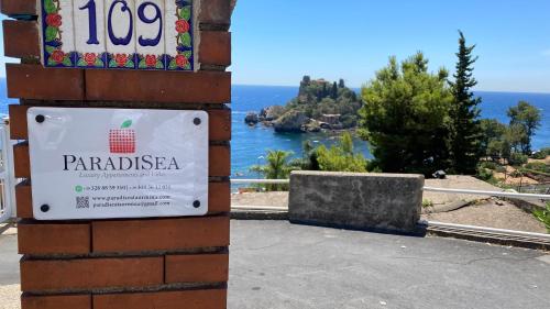 a sign on a building with a view of the ocean at Paradisea Taormina in Taormina