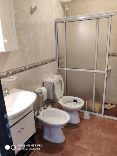 a bathroom with a toilet and a sink and a shower at Casa Quinta in Puerto Rico