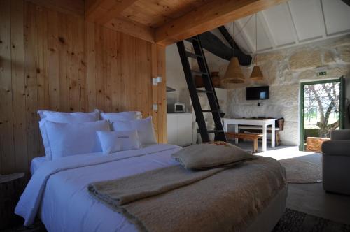 Quinta do Santinho في أمارانتي: غرفة نوم بسرير ابيض كبير مع سلم