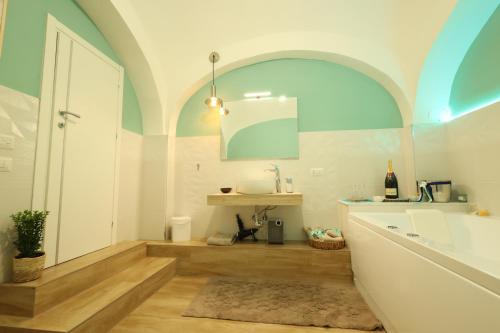 La salle de bains est pourvue d'une baignoire, d'un lavabo et d'un miroir. dans l'établissement DiVi Palace, à Torre Annunziata