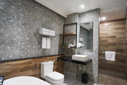 a bathroom with a toilet and a sink and a mirror at Cordela Suites Tasikmalaya in Tasikmalaya