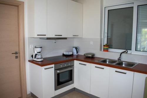 a kitchen with white cabinets and a sink at Greek Villas Justine View Beach in Kyllini