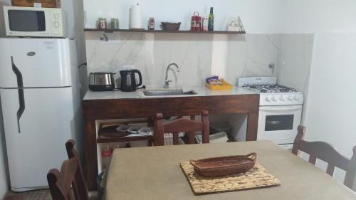 a kitchen with a table and a white refrigerator at Casa Sarmiento in San Francisco del Monte de Oro