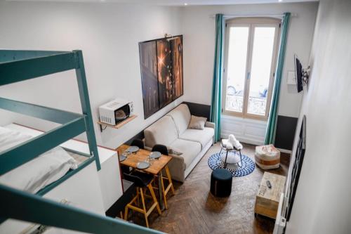 un salon avec un canapé et une table dans l'établissement Centre/Place Jaurès * Studios MyCityHome * Mezzanine, à Saint-Étienne