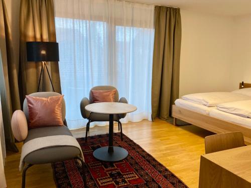 Birkenhof Apartments في باد إندورف: غرفة فندقية بسرير وطاولة وكراسي