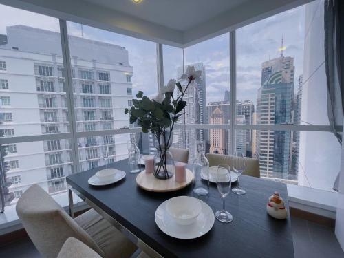 a dining room table with a view of a city at LUX SUITES KL City Pavilion Bukit Bintang with INFINITY POOL in Kuala Lumpur